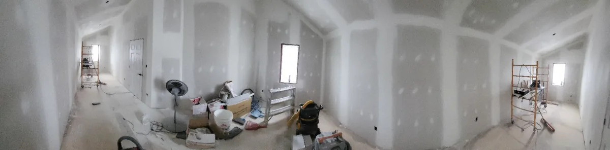 Wide view of a boarded and taped corridor with the crew working along it